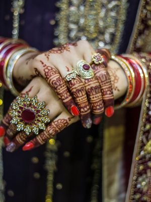 Detailed view of henna adorned hands with jewelry at a traditional Pakistani wedding in Lahore.